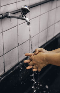 Hand holding water from faucet