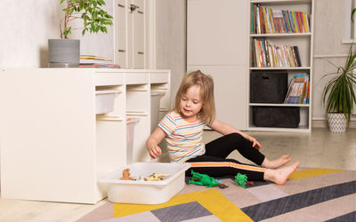Child playing on the floor in dinosaurs in the room. leisure and education at home