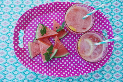 High angle view of watermelon slices with drink in plate on table