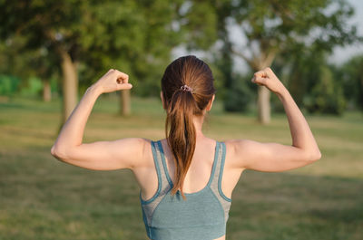 Side view of young woman looking away while standing at park