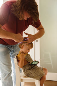 Dad cutting hair to little son