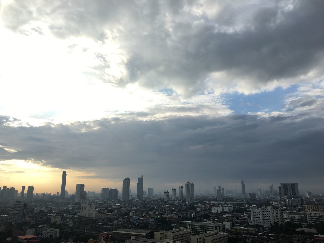 CITY BUILDINGS AGAINST CLOUDY SKY