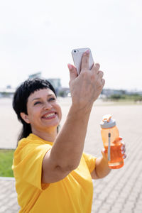 Portrait of smiling young woman using mobile phone