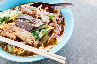 High angle view of fresh meal served in bowl with spoon and chopsticks