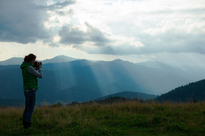 Girl photographer in the carpathian mountains shoots a landscape