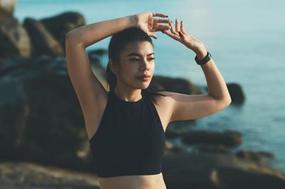 Side view of woman exercising against sky