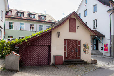 Exterior of houses by building against sky