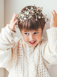 Kid with decorative star tinsel for christmas tree. boy in cable-knit oversized sweater. new year.