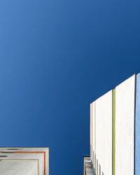 Low angle view of buildings against clear blue sky