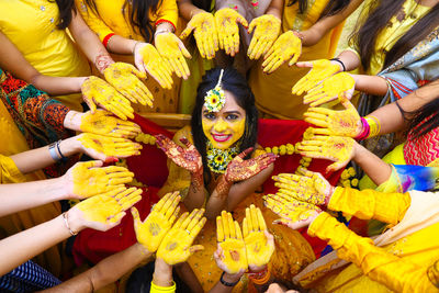 Portrait of smiling bride amidst women during haldi ceremony