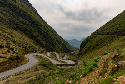 Scenic view of road amidst mountains against sky