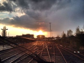 Railroad tracks against cloudy sky