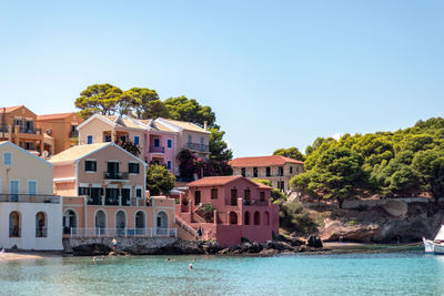 Houses by sea against clear sky