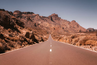 Road amidst trees against sky