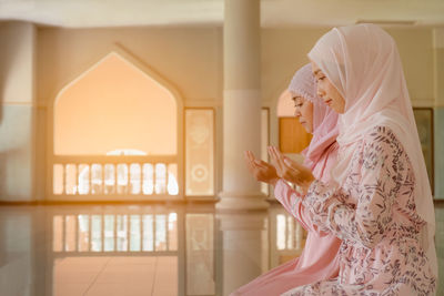 Side view of women praying at mosque