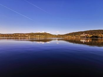 Scenic view of lake against clear blue sky