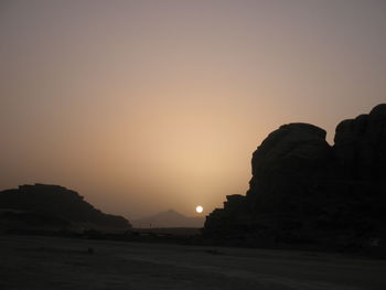 Silhouette rock formations against sky during sunset