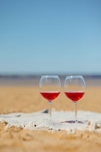 Two glasses of red wine or juice at a on the beach for a couple of lovers on a date