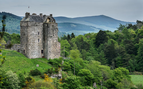 Scottish landscape with ancient castle and surrounding woodlands