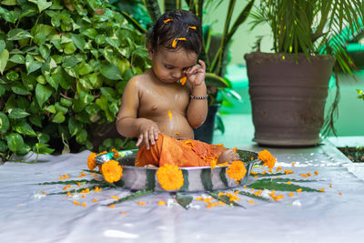 Cute toddler baby boy bathing in decorated bathtub at outdoor from unique perspective