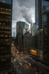 Traffic on road amidst buildings in city against sky