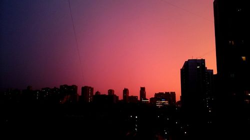 Silhouette buildings against sky during sunset