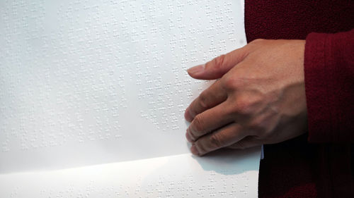 Close-up of human hand on book