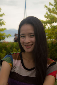 Portrait of smiling young woman at park