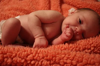 Portrait of baby girl lying on bed