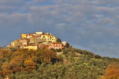 Buildings on hill against sky