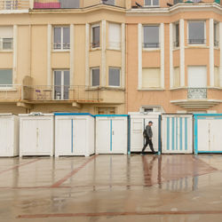 Full length side view of man walking against building