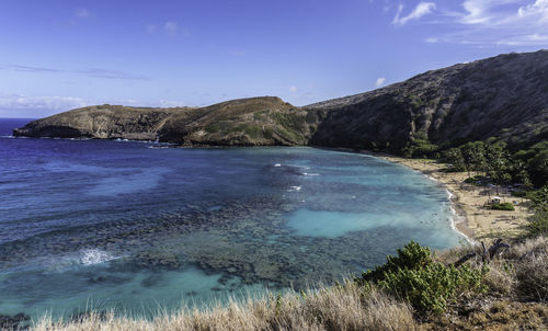 Scenic view of sea and mountains against sky