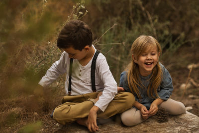 Siblings sitting outdoors