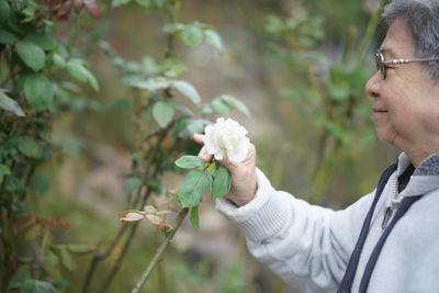 Side view of man holding flowers