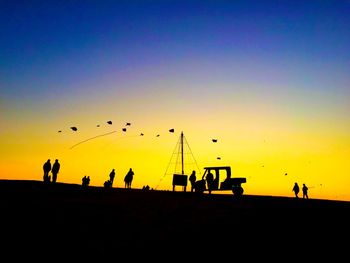 Silhouette people against sky at sunset