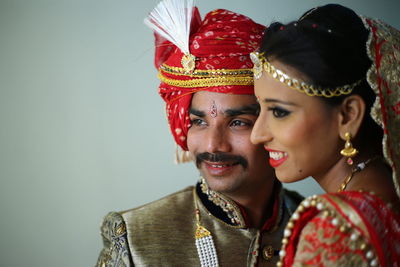 Smiling young couple standing against wall