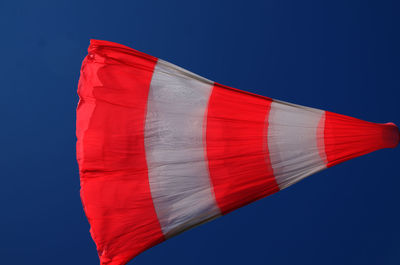 Low angle view of windsock flag against clear blue sky