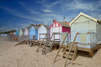 Beach huts by buildings against sky