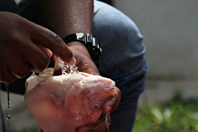 Midsection of man washing fish at market for sale