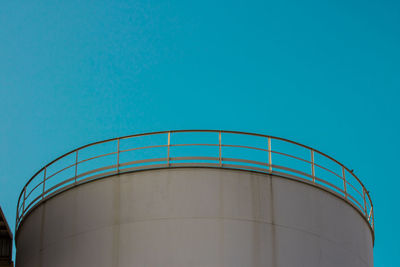 Low angle view of factory against clear blue sky