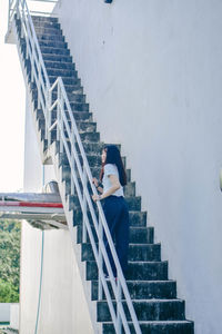 Low angle view of person standing on staircase against buildings