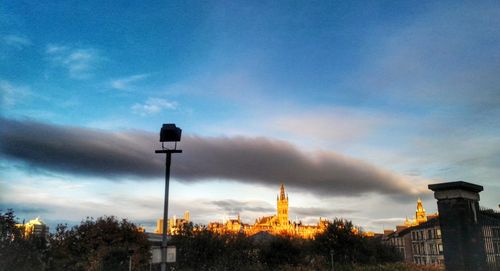 Low angle view of illuminated building against dramatic sky