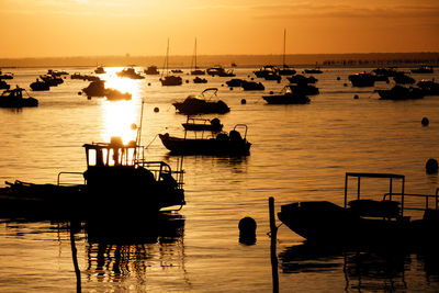 Boats in calm sea at sunset