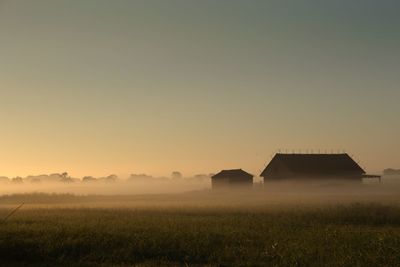 Scenic view of field against clear sky during sunset