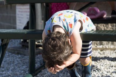 Boy leaning on bench