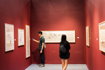 Rear view of people looking at corridor in museum