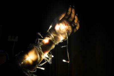 Close-up of hand holding illuminated lighting equipment