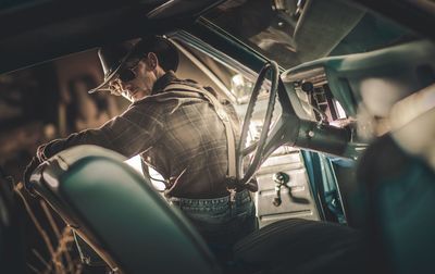 Portrait of man sitting in car at night