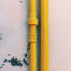 Close-up of yellow pipe on wall