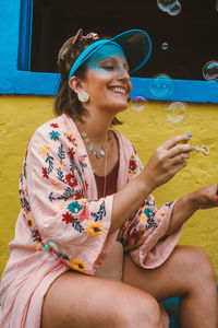 Happy young woman looking at bubbles